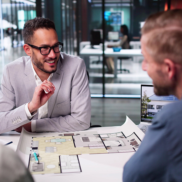 Beratungsgespräch über Bauplänen von Häusern