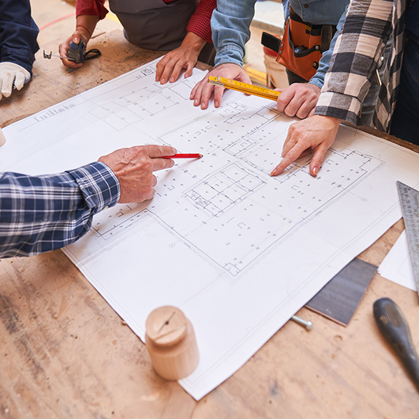 Team diskutiert über Bauplänen von Häusern
